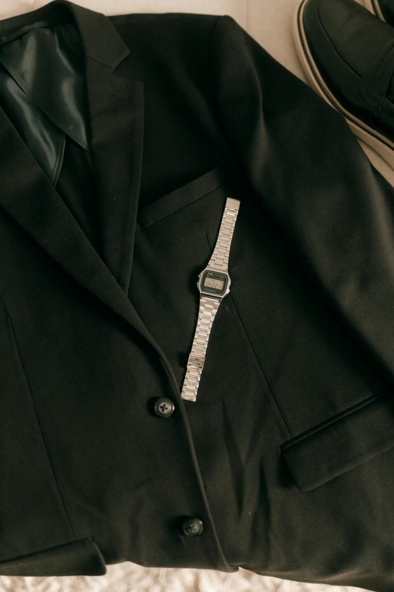 A refined black suit with a vintage wristwatch, exuding timeless elegance and style.